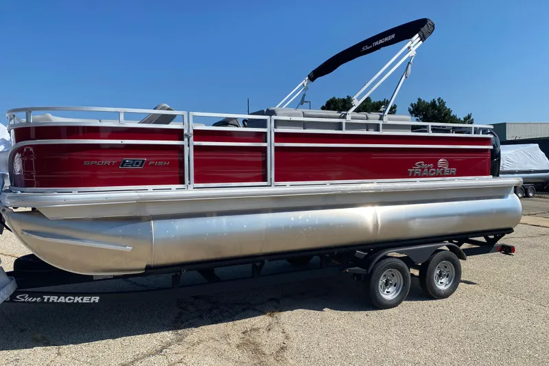 The Image of 2026 Sun Tracker SportFish 20 DLX pontoon boat on trailer, red and silver design. - 0