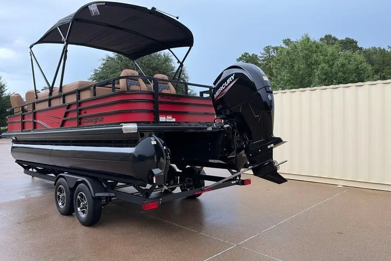 Slide: The Image of 2026 Ranger 220FC pontoon boat on trailer with Mercury outboard motor, parked outdoors. - 2