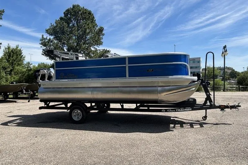 Slide: The Image of 2026 Sun Tracker Party Barge 18 DLX pontoon boat on trailer, parked outdoors. - 3