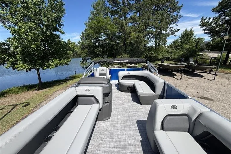 Slide: The Image of 2026 Sun Tracker Party Barge 18 DLX pontoon boat with spacious seating by a serene lake. - 5
