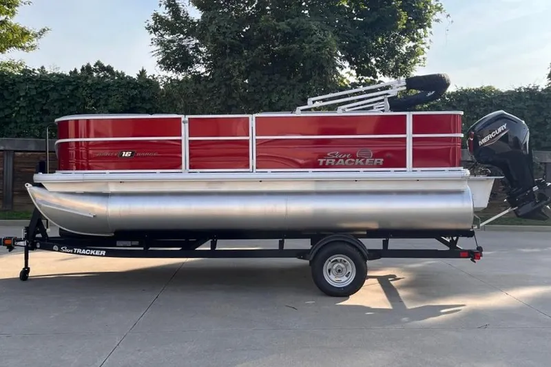 Slide: The Image of 2026 Sun Tracker Party Barge 18 DLX pontoon boat on trailer, red and silver design. - 1