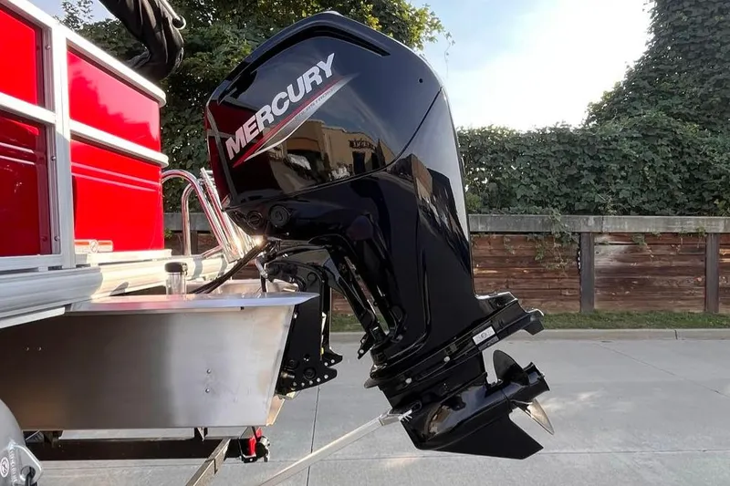 Slide: The Image of 2026 Sun Tracker Party Barge 18 DLX with Mercury outboard motor, parked outdoors. - 3