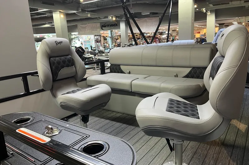Slide: The Image of 2026 Ranger 220F boat interior with plush seating and modern design in showroom. - 8