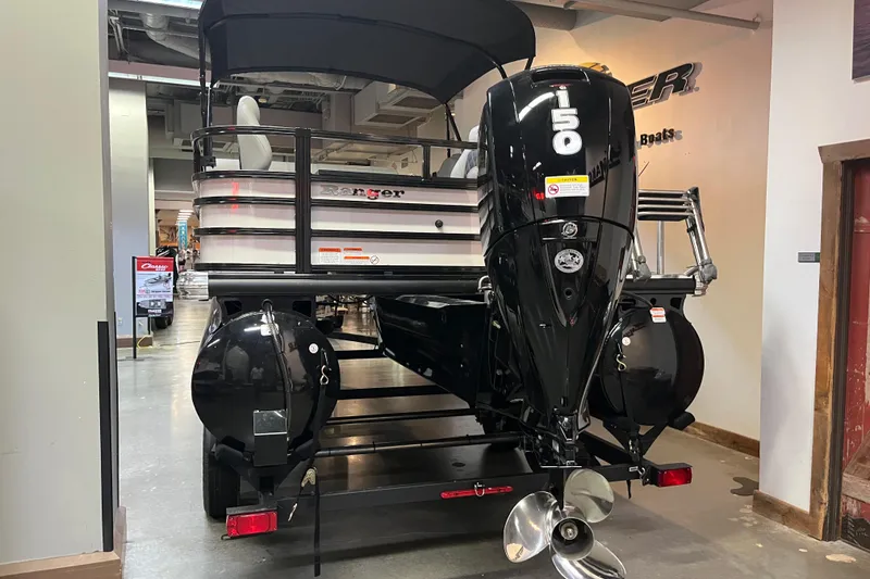 Slide: The Image of 2026 Ranger 220F boat with powerful outboard motor displayed indoors. - 5