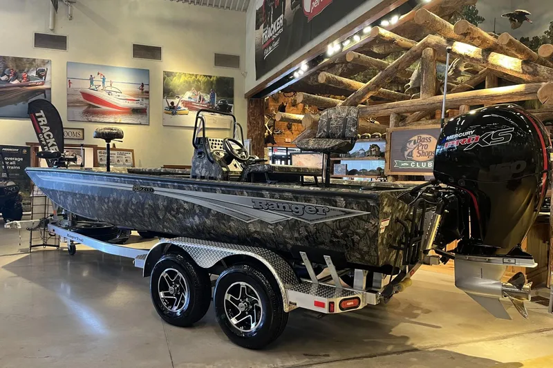 Slide: The Image of 2026 Ranger RB200 boat with camo design and Mercury Pro XS engine in showroom. - 2