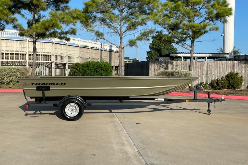Slide: The Image of 2026 Tracker Grizzly 1754 Utility boat on trailer, parked outdoors under trees. - 3