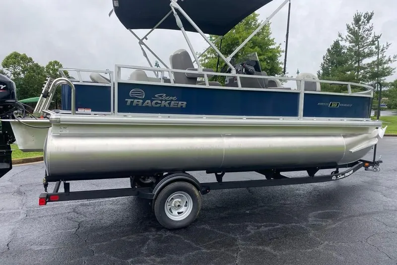 The Image of 2026 Sun Tracker Bass Buggy 18 DLX pontoon boat on trailer, parked outdoors. - 0