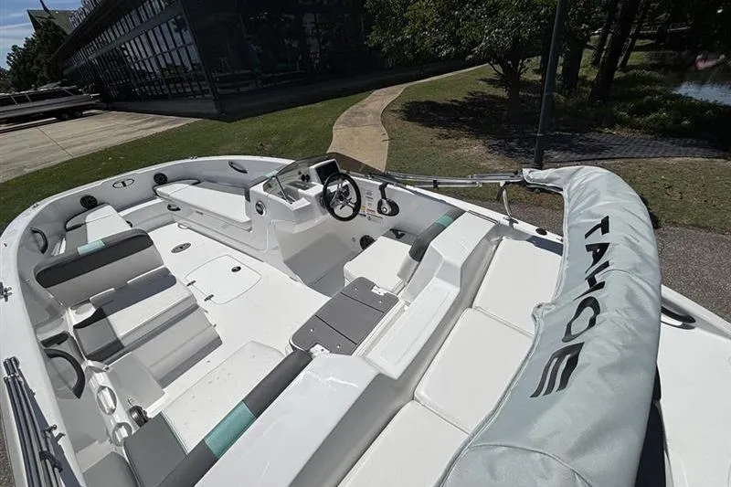 Slide: The Image of 2026 Tahoe T18 boat interior with seating and steering wheel, parked near a building. - 10