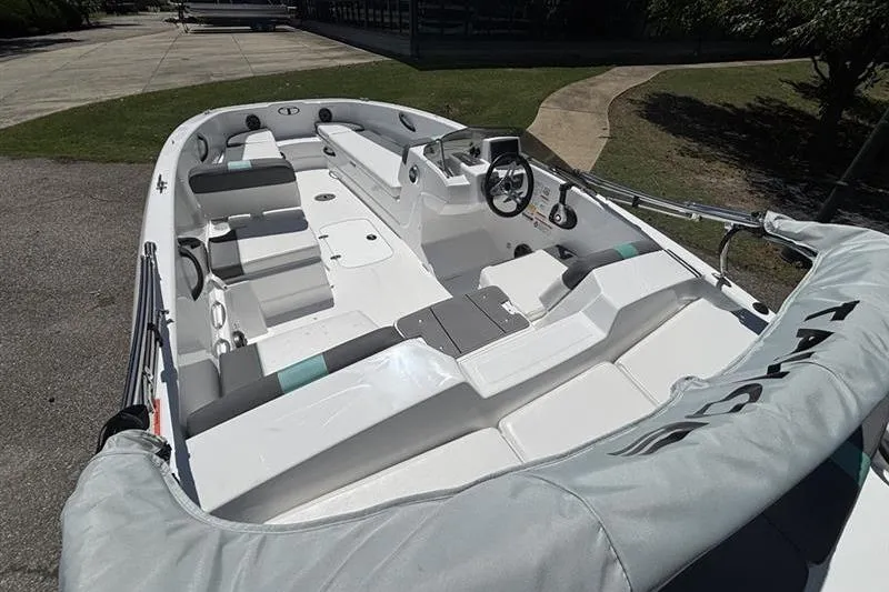 Slide: The Image of 2026 Tahoe T18 boat interior with seating and steering wheel, parked outdoors. - 14