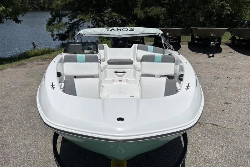 Slide: The Image of 2026 Tahoe T18 boat with sleek white design, parked near a serene lake. - 2