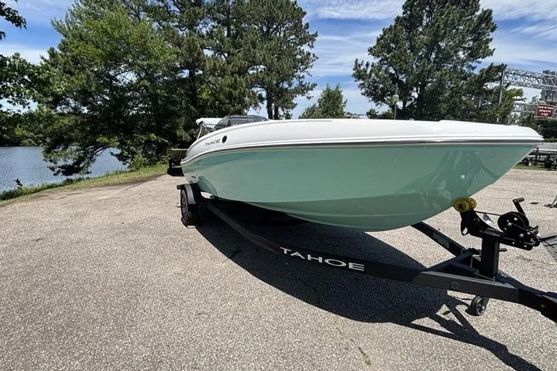 Slide: The Image of 2026 Tahoe T18 boat on trailer by lakeside, surrounded by trees and clear sky. - 4