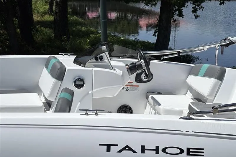 Slide: The Image of 2026 Tahoe T18 boat interior with steering wheel, white seating, and lake view. - 7