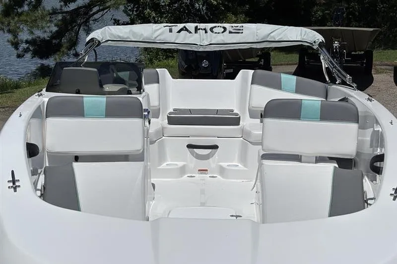 Slide: The Image of 2026 Tahoe T18 boat interior with white and gray seating, docked by a lake. - 8