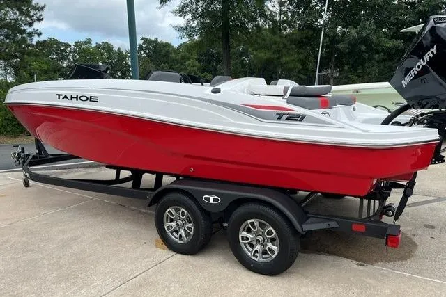 Slide: The Image of 2026 Tahoe T21 boat in red and white on a trailer, parked outdoors. - 1