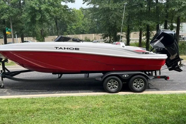 Slide: The Image of 2026 Tahoe T21 boat on trailer, red and white design, parked outdoors. - 1