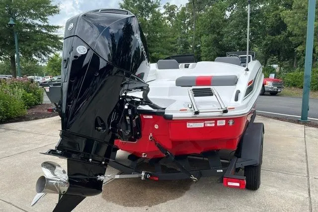 Slide: The Image of 2026 Tahoe T21 boat with powerful outboard motor, red and white design, parked on trailer. - 4