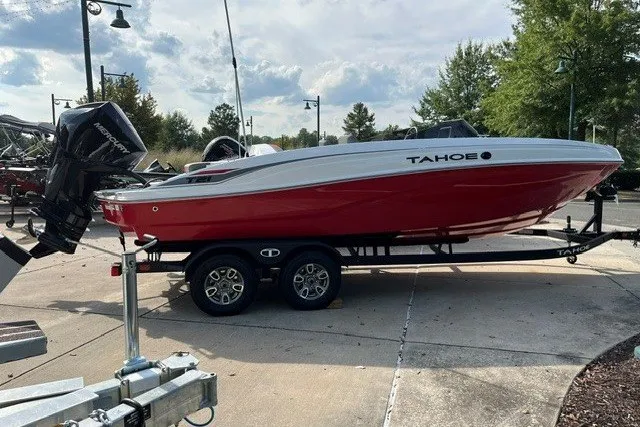 The Image of 2026 Tahoe T21 boat in red and white on a trailer, parked outdoors. - 0