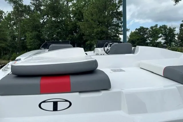 Slide: The Image of 2026 Tahoe T21 boat with sleek design, gray and red seating, and lush green backdrop. - 5
