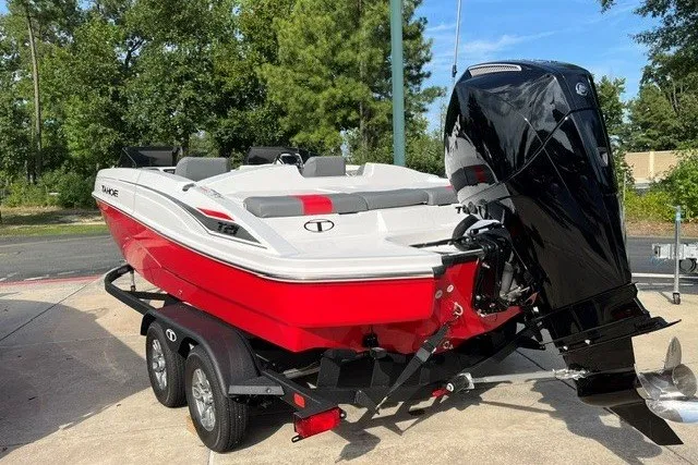 Slide: The Image of 2026 Tahoe T21 boat in red and white on a trailer, parked outdoors. - 16