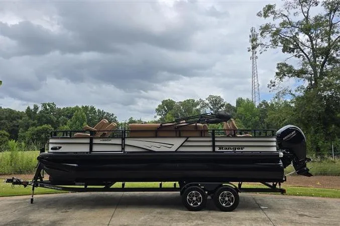 Slide: The Image of 2026 Ranger 220F pontoon boat on trailer, parked outdoors under cloudy sky. - 4