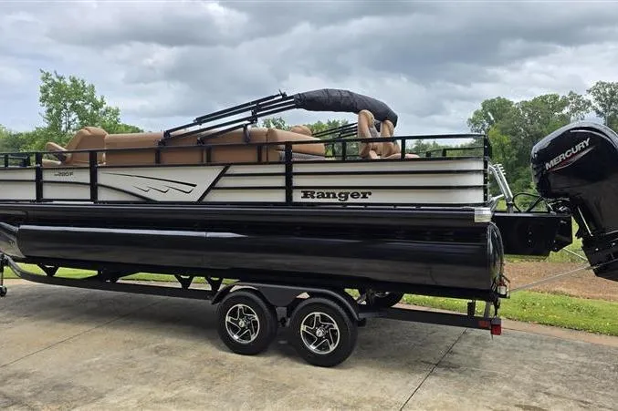 Slide: The Image of 2026 Ranger 220F pontoon boat with Mercury engine on a trailer, parked outdoors. - 6