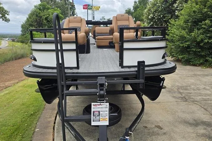 Slide: The Image of 2026 Ranger 220F pontoon boat with tan seating, parked on a trailer. - 2