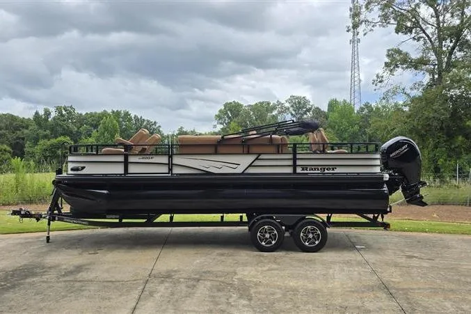 Slide: The Image of 2026 Ranger 220F pontoon boat on trailer, parked outdoors under cloudy sky. - 5