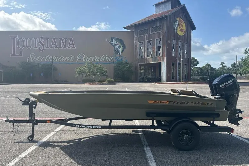 Slide: The Image of 2026 Tracker Grizzly 1756 T Marsh boat in parking lot, Louisiana Sportsman's Paradise backdrop. - 2