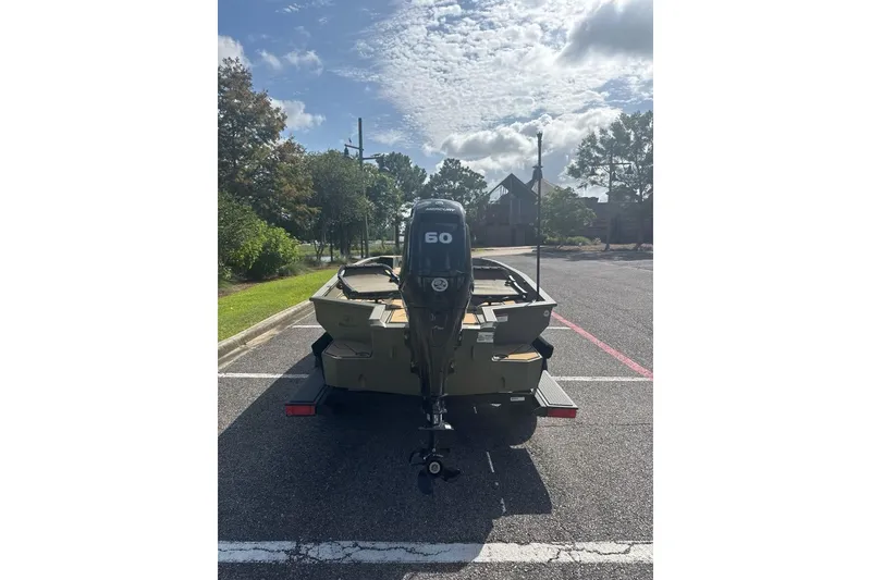 Slide: The Image of 2026 Tracker Grizzly 1756 T Marsh boat with 60 HP motor in parking lot. - 3
