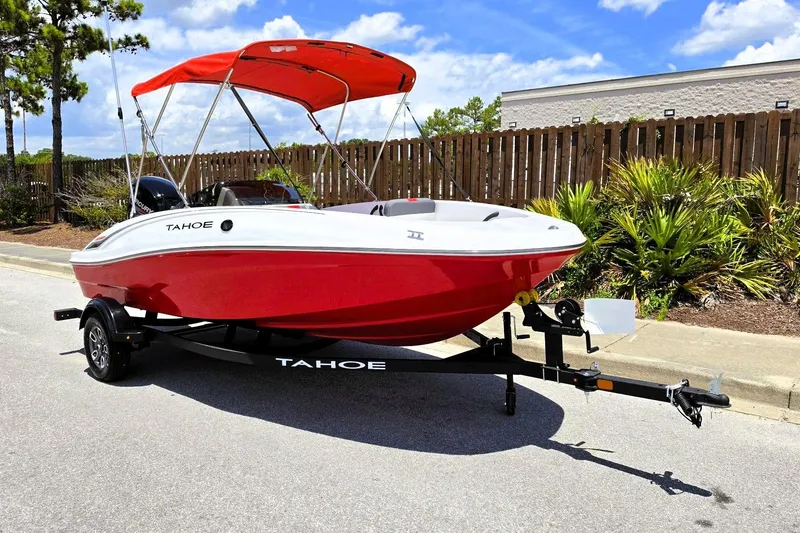 Slide: The Image of 2026 Tahoe T16 boat with red hull and canopy on trailer, parked outdoors. - 5