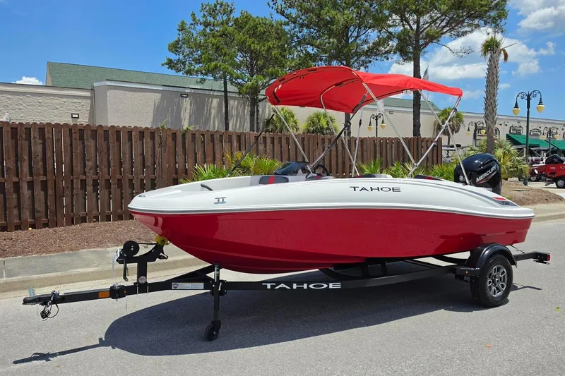 Slide: The Image of 2026 Tahoe T16 boat with red hull and canopy on trailer, parked outdoors. - 8