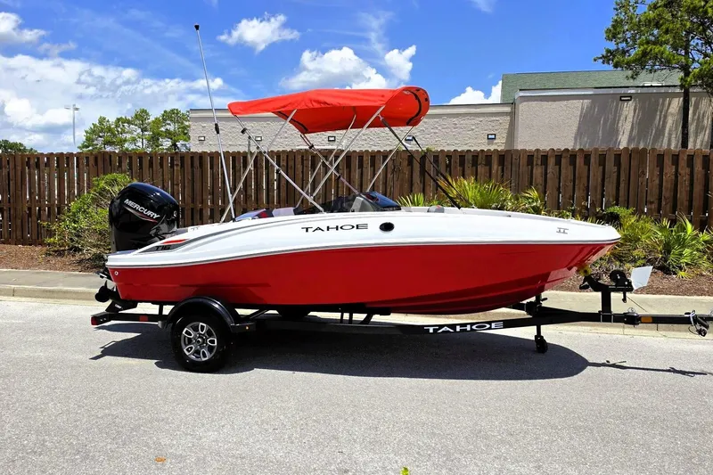 Slide: The Image of 2026 Tahoe T16 boat with red hull and canopy on a trailer, parked outdoors. - 4