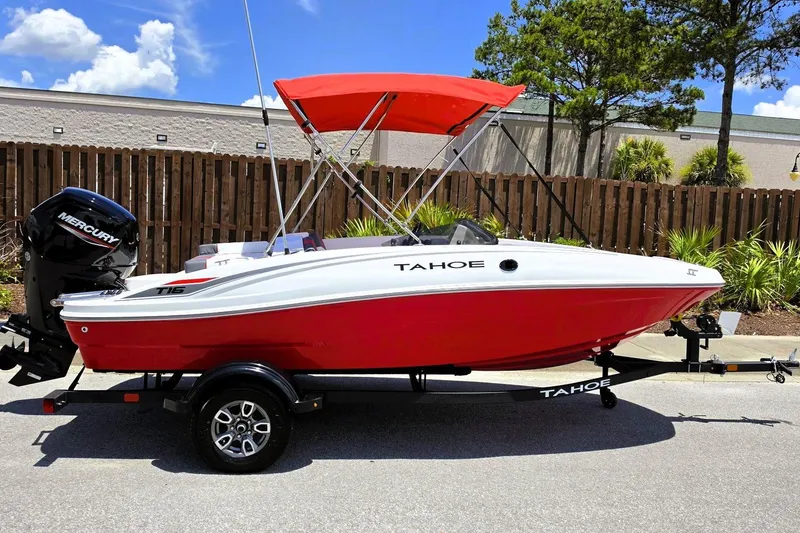 The Image of 2026 Tahoe T16 boat with red hull and Mercury engine, parked outdoors. - 0