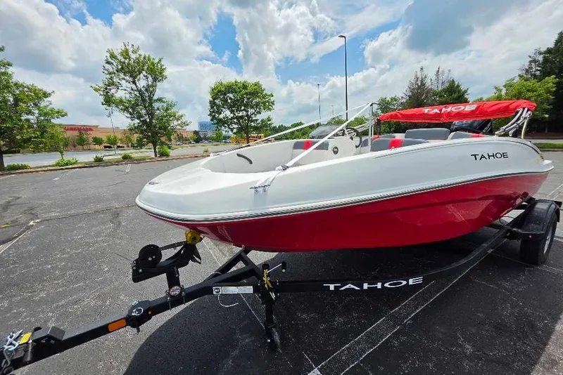 Slide: The Image of 2026 Tahoe T16 boat with red and white design on a trailer in a parking lot. - 6