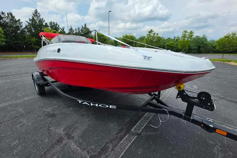 The Image of 2026 Tahoe T16 boat with red and white design on a trailer in a parking lot. - 0