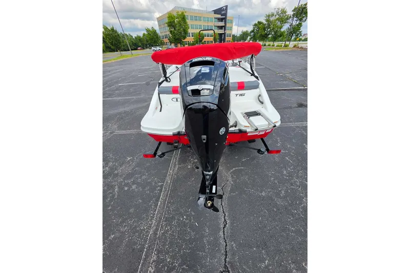 Slide: The Image of 2026 Tahoe T16 boat with red canopy and outboard motor in parking lot. - 3