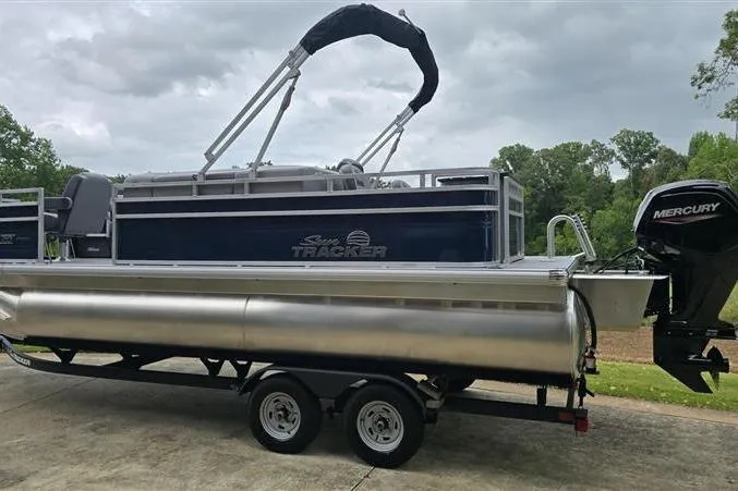 Slide: The Image of 2026 Sun Tracker SportFish 20 DLX pontoon boat on trailer, featuring Mercury outboard motor. - 5