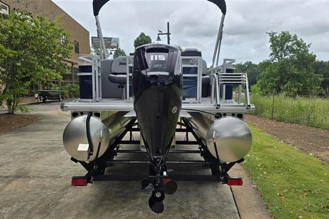 Slide: The Image of 2026 Sun Tracker SportFish 20 DLX pontoon boat with Mercury 115 engine, parked outdoors. - 6