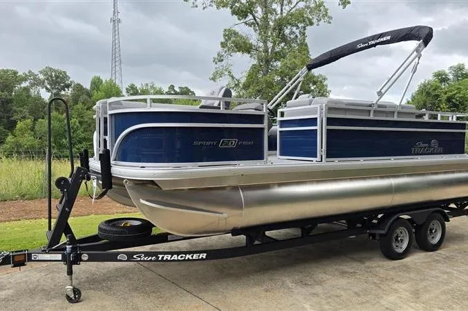 Slide: The Image of 2026 Sun Tracker SportFish 20 DLX pontoon boat on trailer, parked outdoors. - 3