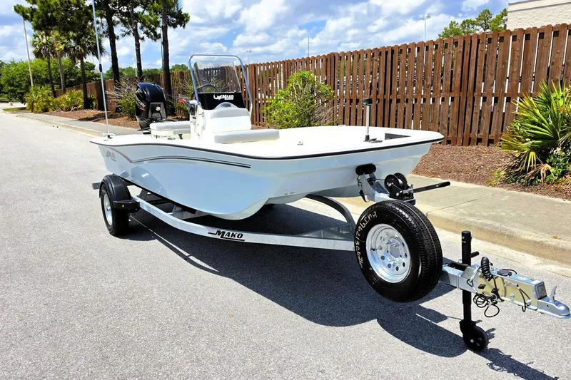 Slide: The Image of 2026 Mako Pro Skiff 15 CC boat on trailer, parked on a sunny street. - 5
