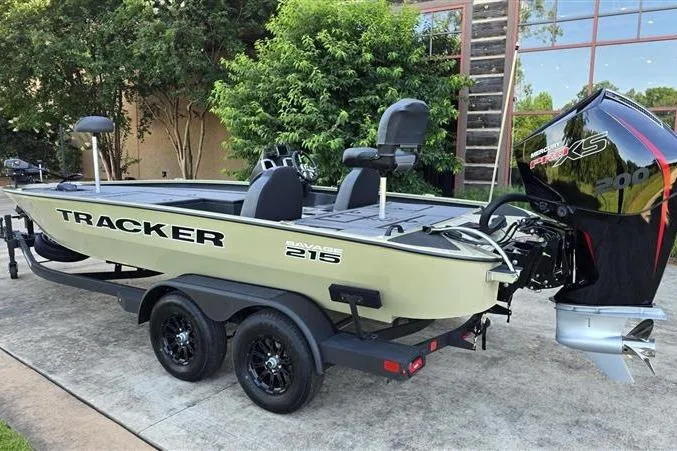 Slide: The Image of 2026 Tracker Savage 215 boat on trailer with powerful outboard motor, parked outdoors. - 2