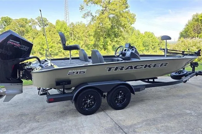 Slide: The Image of 2026 Tracker Savage 215 boat on trailer, parked outdoors with lush greenery background. - 4