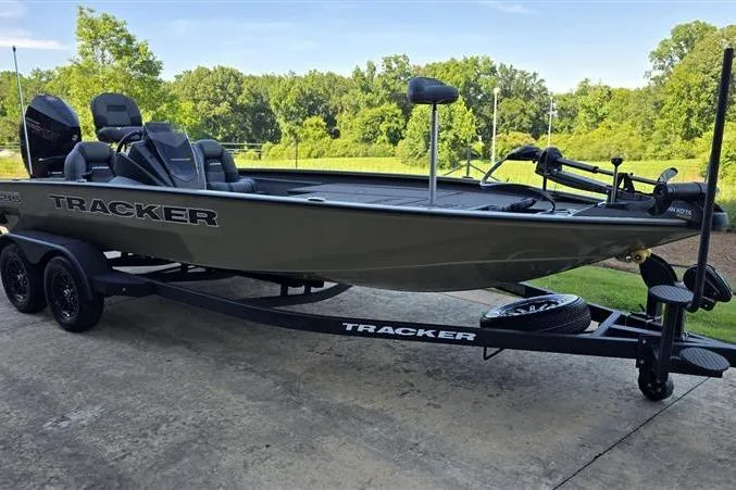 Slide: The Image of 2026 Tracker Savage 215 boat on trailer, parked outdoors with lush greenery background. - 5