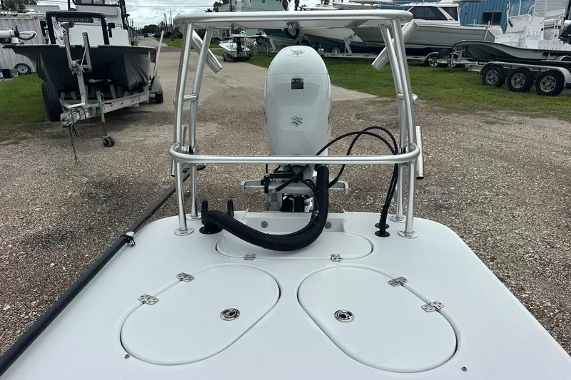 Slide: The Image of 2024 Ankona Advent boat with Suzuki outboard motor, parked on gravel lot. - 6