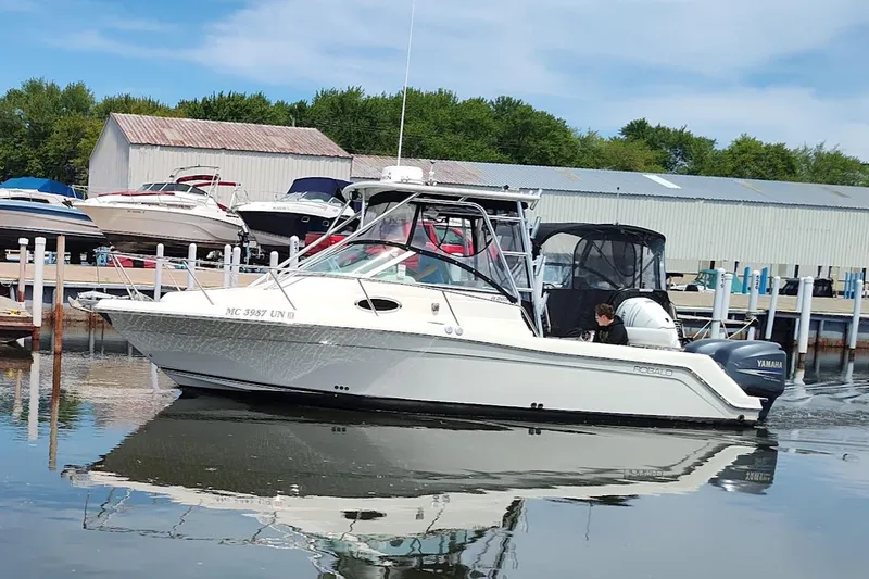 Slide: The Image of 2005 Robalo R265 Walkaround boat docked at marina with Yamaha engine. - 2
