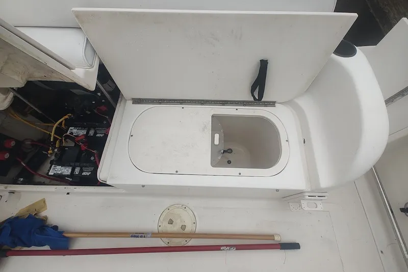Slide: The Image of 2005 Robalo R265 Walkaround boat interior with storage compartment and battery setup. - 23