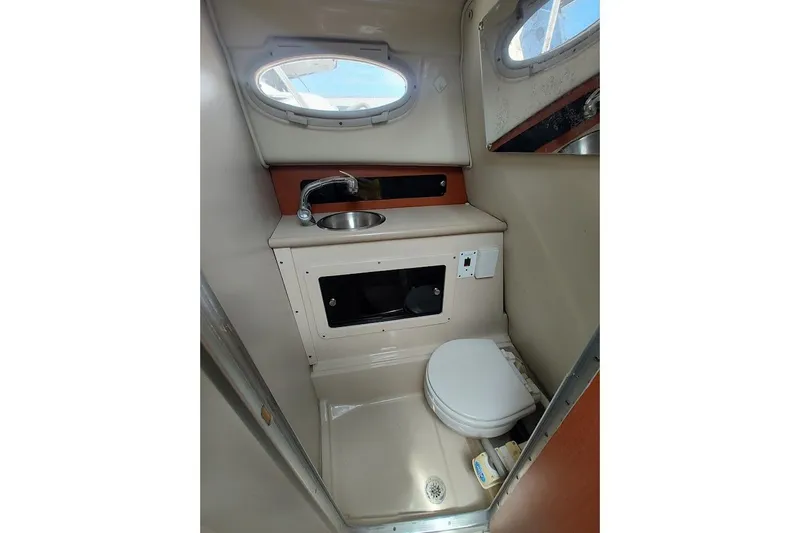 Slide: The Image of 2005 Robalo R265 Walkaround boat interior with sink and toilet in compact bathroom. - 21
