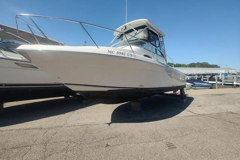 Slide: The Image of 2005 Robalo R265 Walkaround boat on dry dock under clear blue sky. - 4