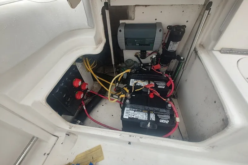 Slide: The Image of 2005 Robalo R265 Walkaround boat battery compartment with wiring and electrical components. - 25