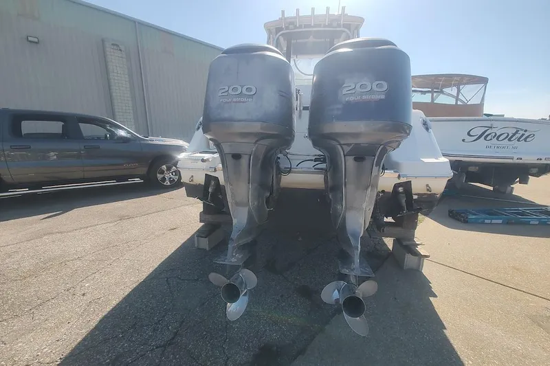 Slide: The Image of 2005 Robalo R265 Walkaround with twin 200 horsepower outboard engines, parked outdoors. - 7